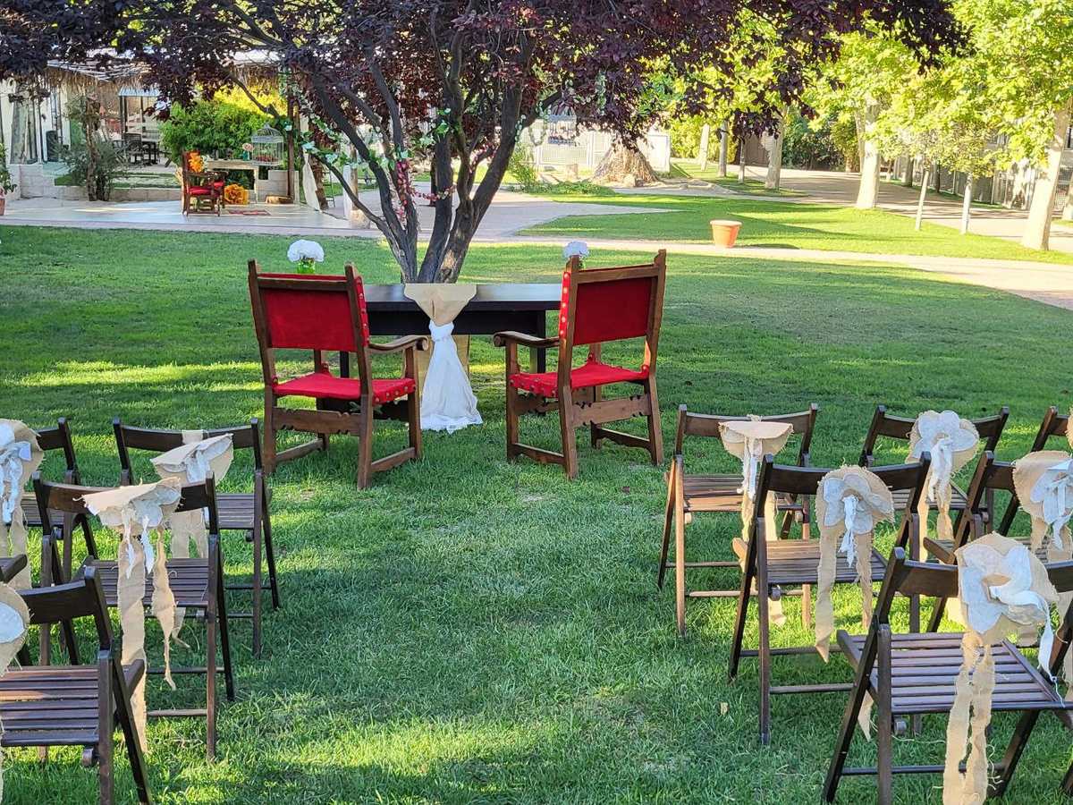 Sillones rojos bajo un árbol para una ceremonia íntima